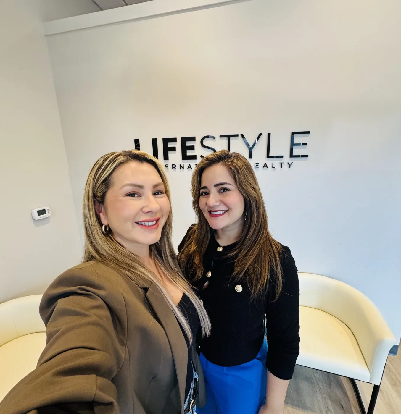 Jenny Caso con una agente en la oficina de Lifestyle International Realty