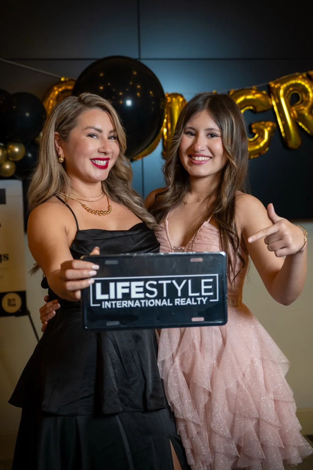 Jenny Caso celebrando con la placa de Lifestyle International Realty